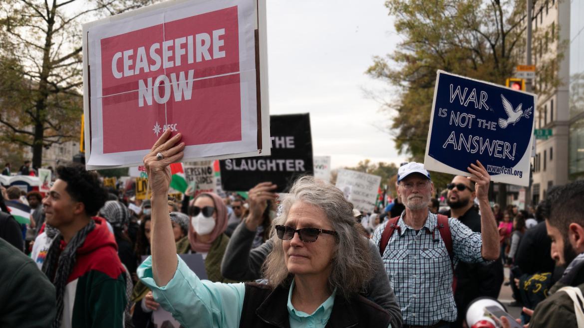 Advocates march in the streets of Washington, DC holding signs that say, "Ceasefire Now" and "War is Not the Answer"