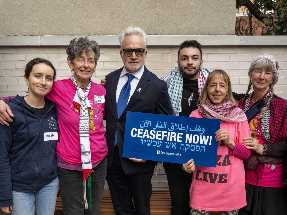 Ceasefire sign held by Bradley Whitford and other advocates