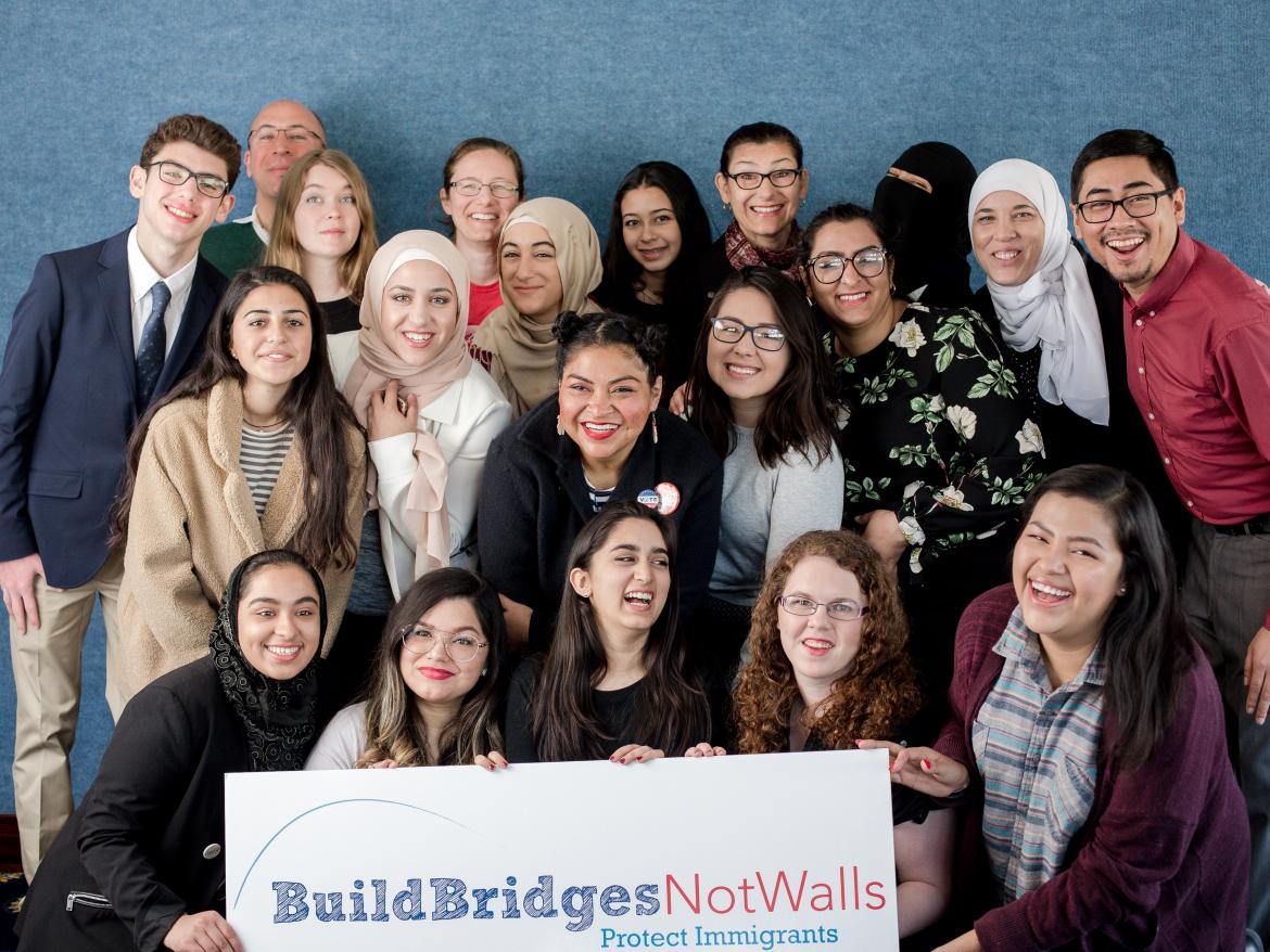 Spring Lobby Weekend participants holding sign that says "build bridges, not walls"