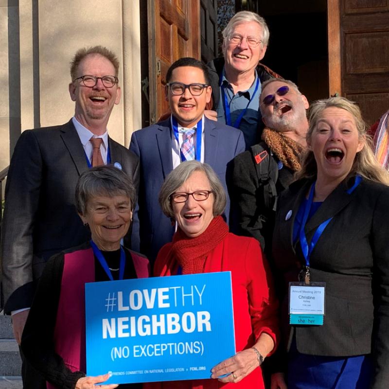 Group holding Love They Neighbor sign at annual meeting 2019