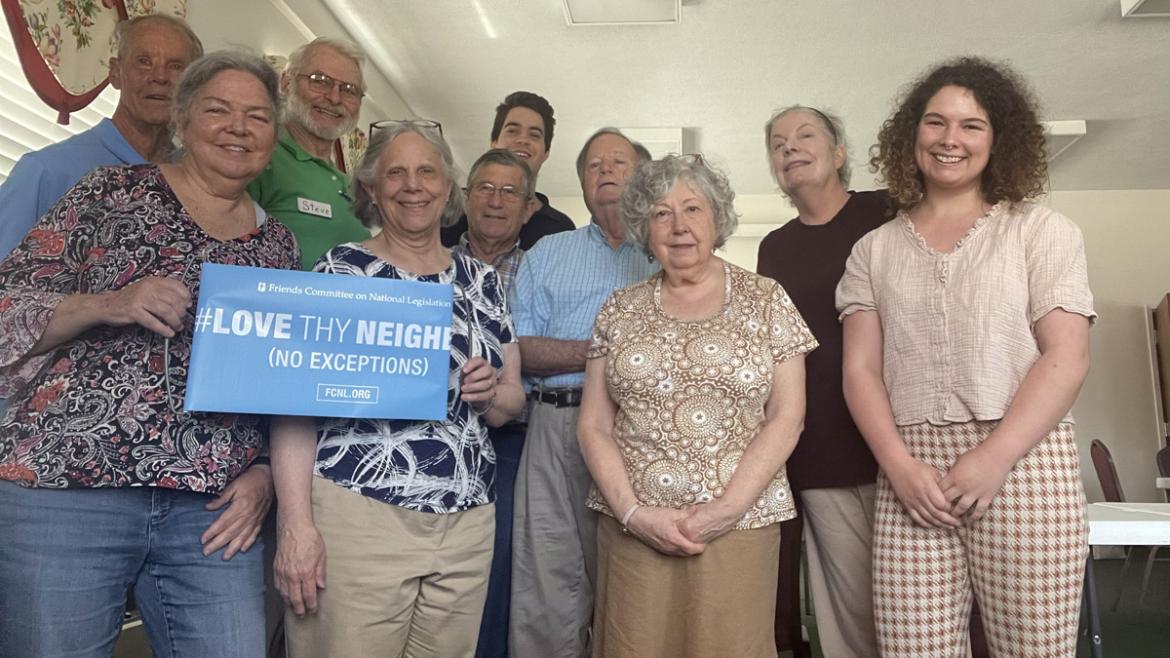 Jus and Clare visit Friends in West Virginia - group smiles and holds a sign that says "Love Thy Neighbor (No Exceptions)"