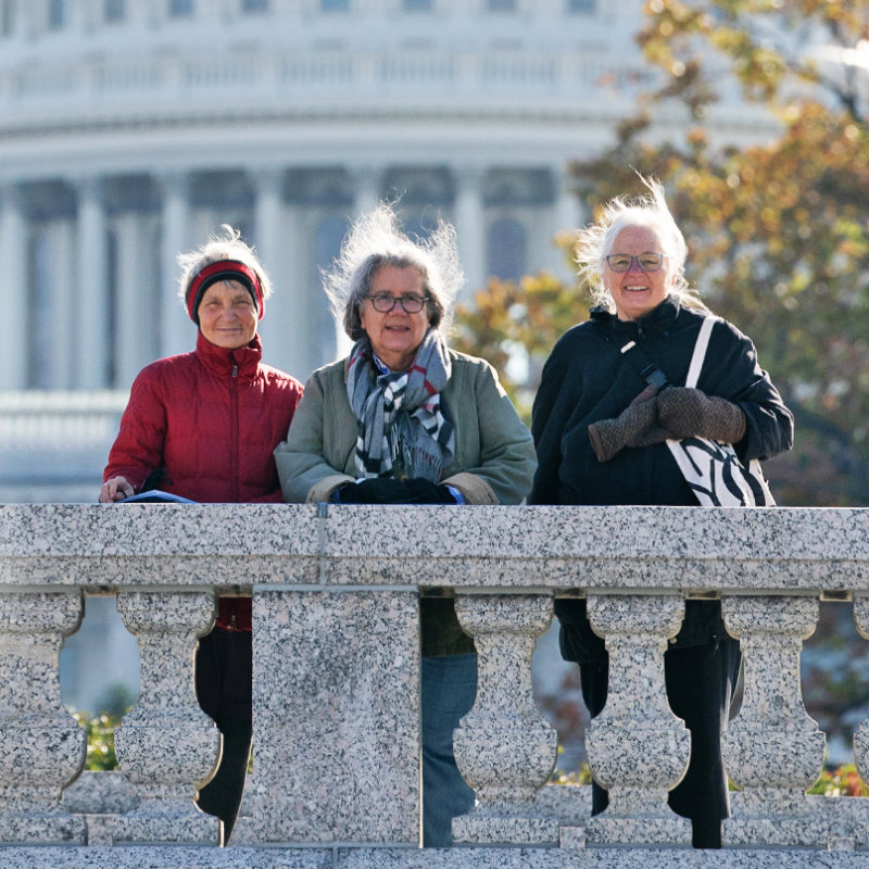 Annual Meeting promotional graphic. Image - three women standing in front of U.S. Capitol smiling. Text: "Justice Calls Us. Love Unites Us. 2023 Annual Meeting and Quaker Public Policy Institute"