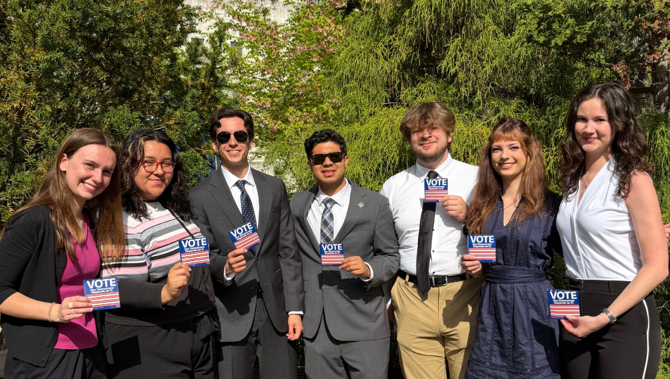 Young people professionally dressed with "Vote" stickers