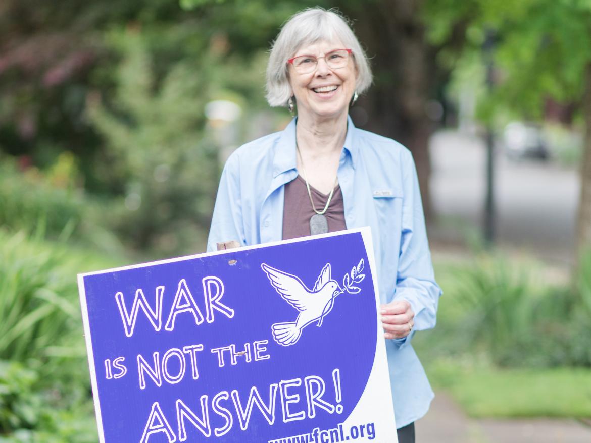 Marge Abbot holding sign that says "War is Not the Answer"