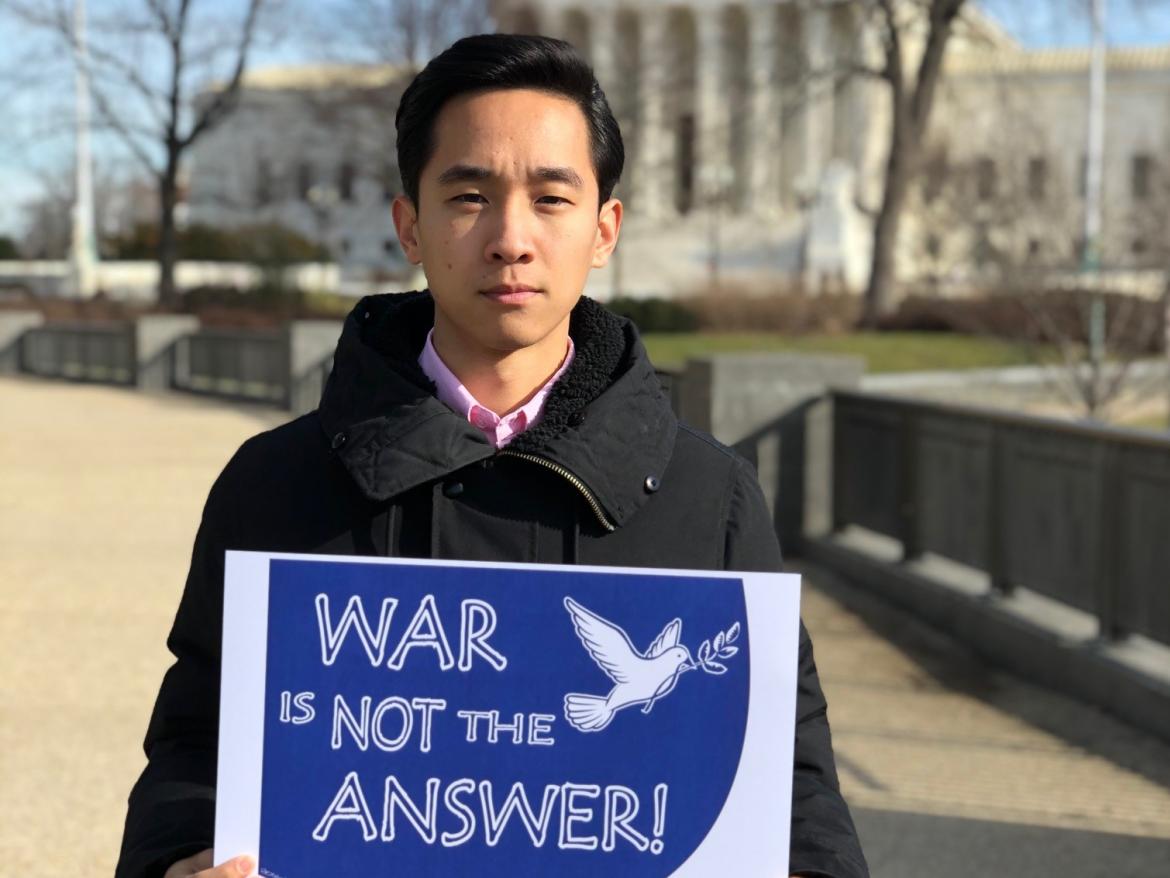 Don Chen holds War is Not the Answer sign
