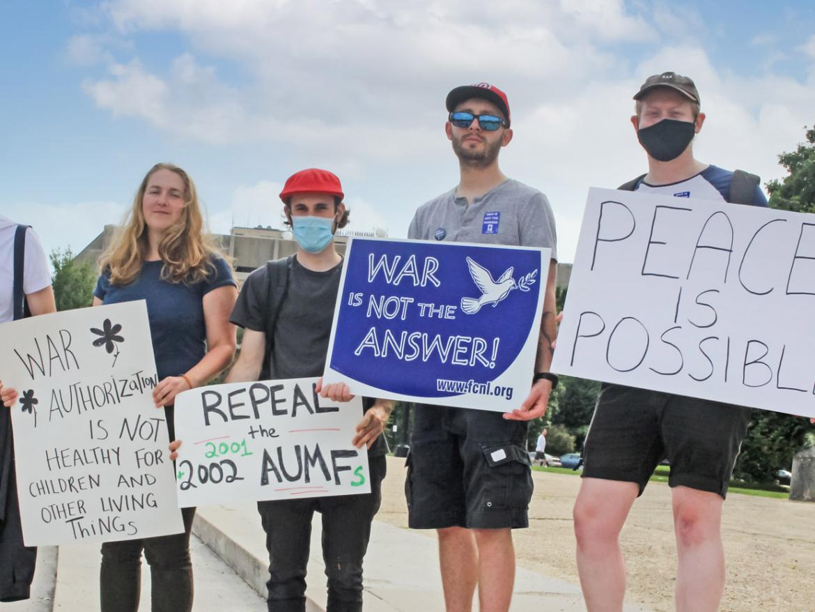 FCNL Advocates holding "war is not the answer" and "Peace is possible" signs