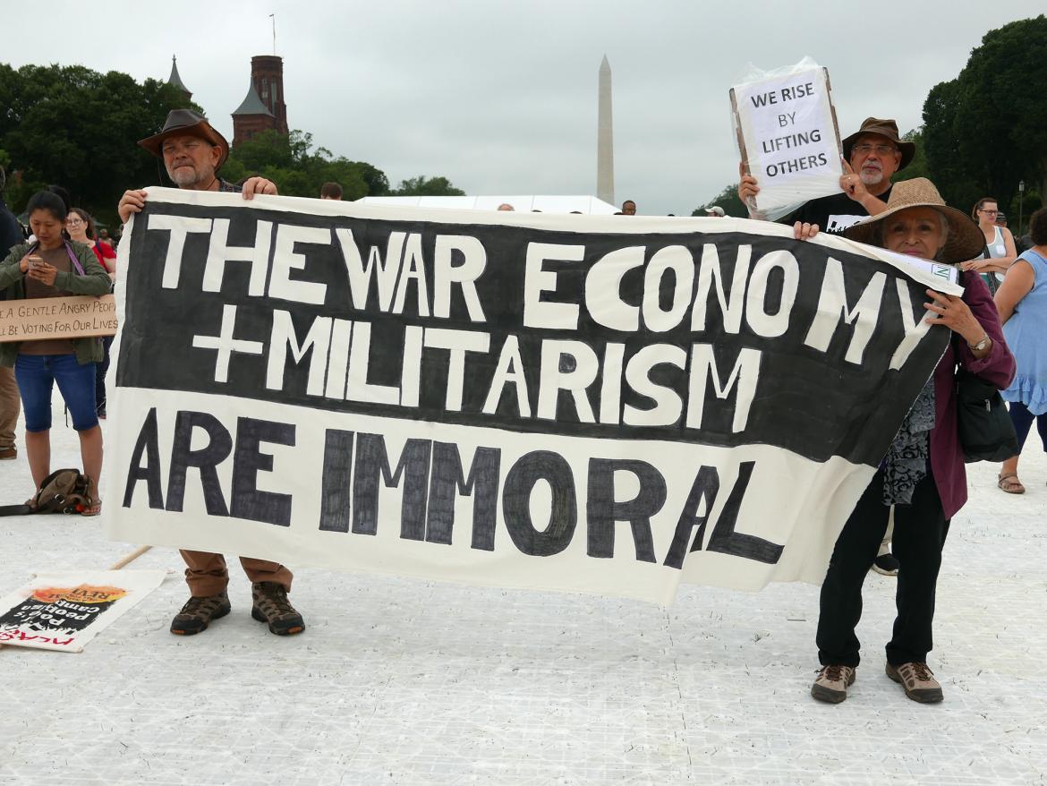 Marches hold sign that says "the war economy and militarism are immoral" at the 2018 Poor Peoples Campaign rally