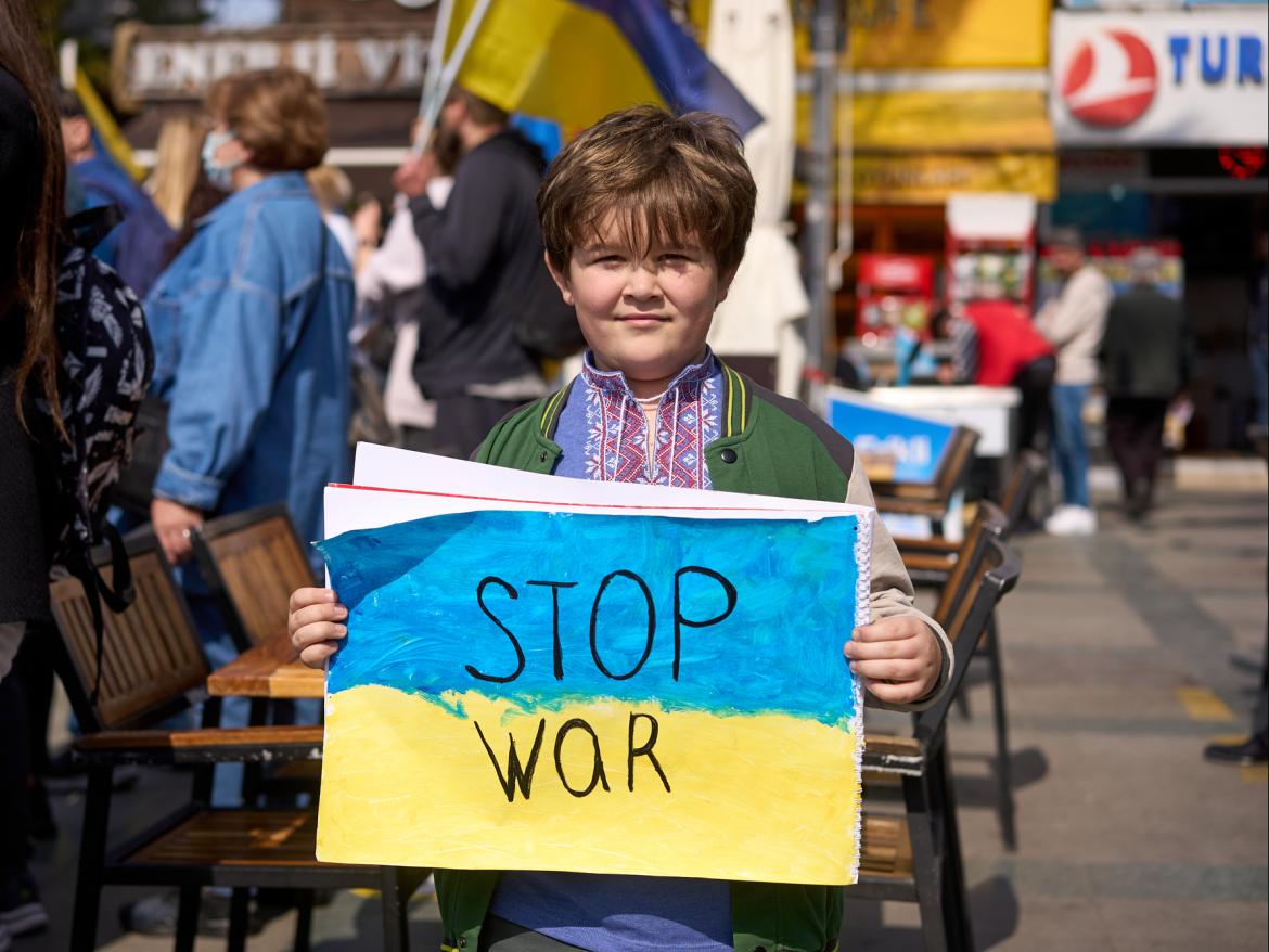 Boy holding "stop war" sign at Ukraine war protest in Turkey
