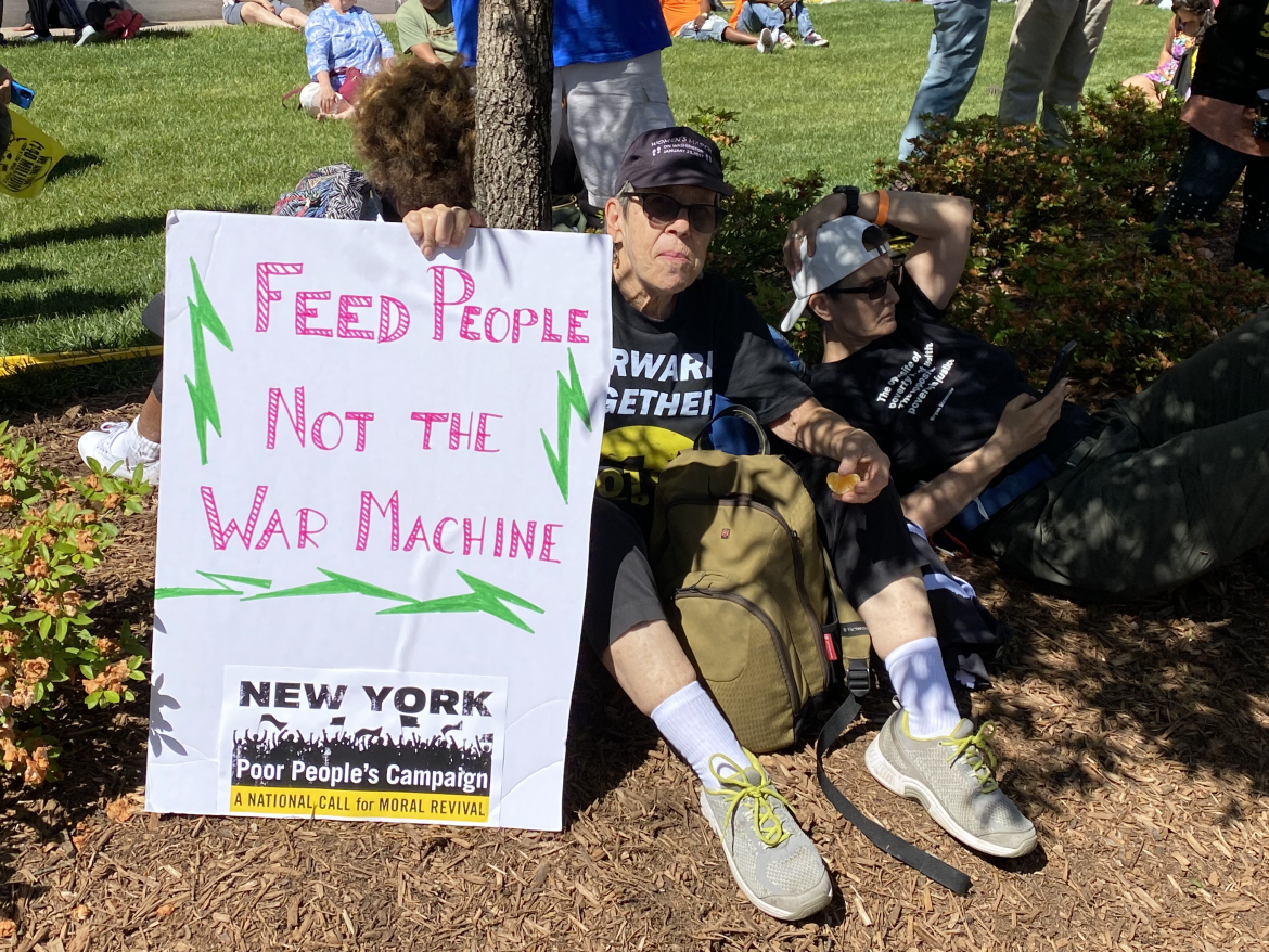 A demonstrator holds a sign that reads, "Feed People, not the war machine," at the Poor People's Campaign Moral March on Washington