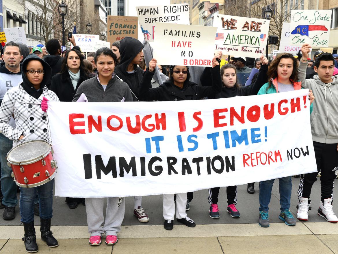 Marchers hold a sign that says "enough is enough! It is time! Immigration refor now"