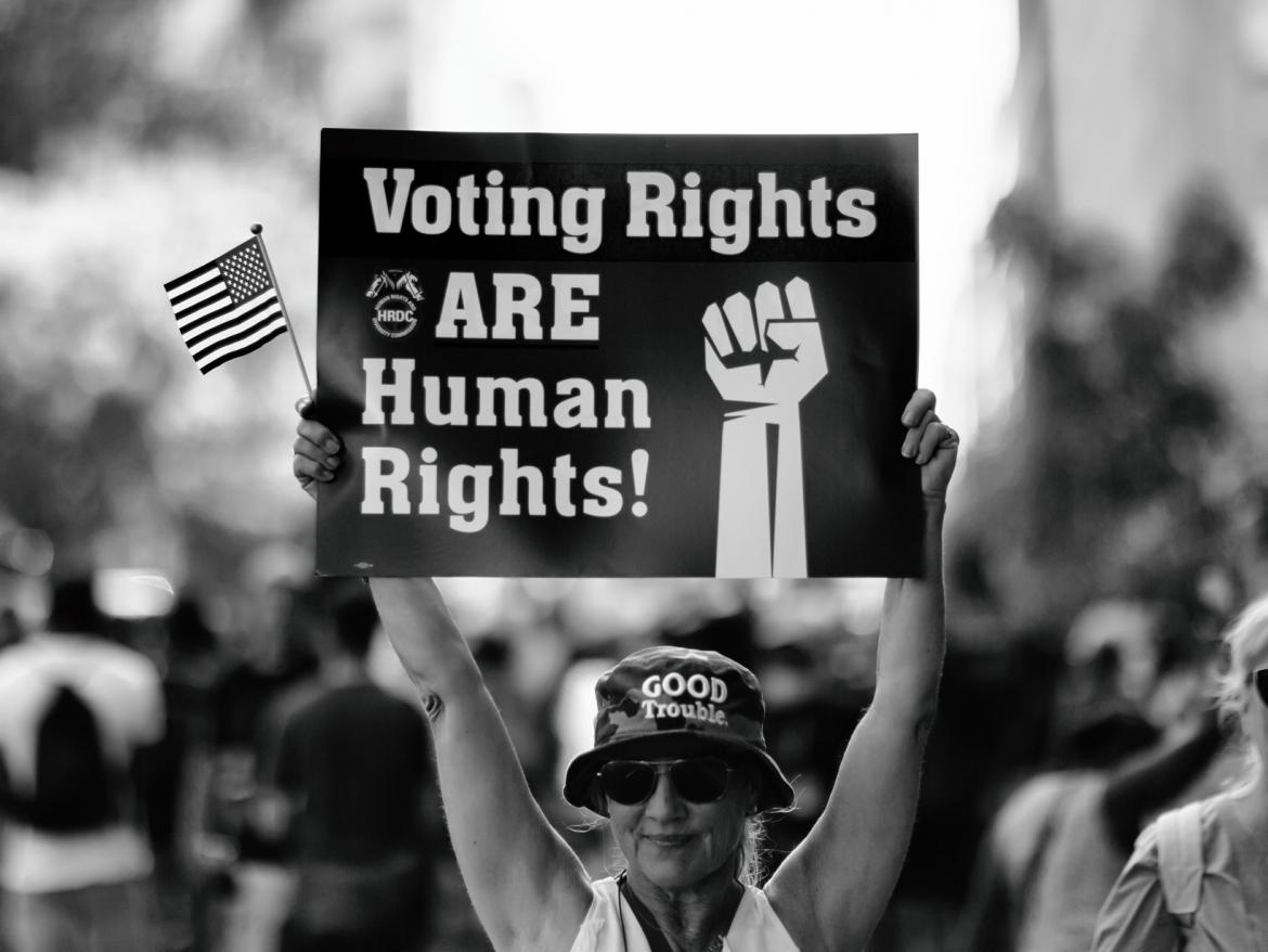 Woman holding a sign that says: "Voting Rights are Human Rights"