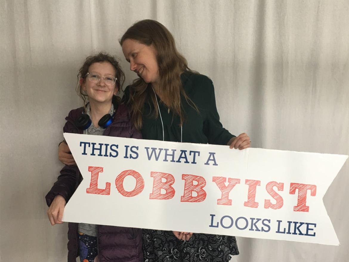 Alicia McBride and Mandy hold a sign that reads "This is what a lobbyist looks like."