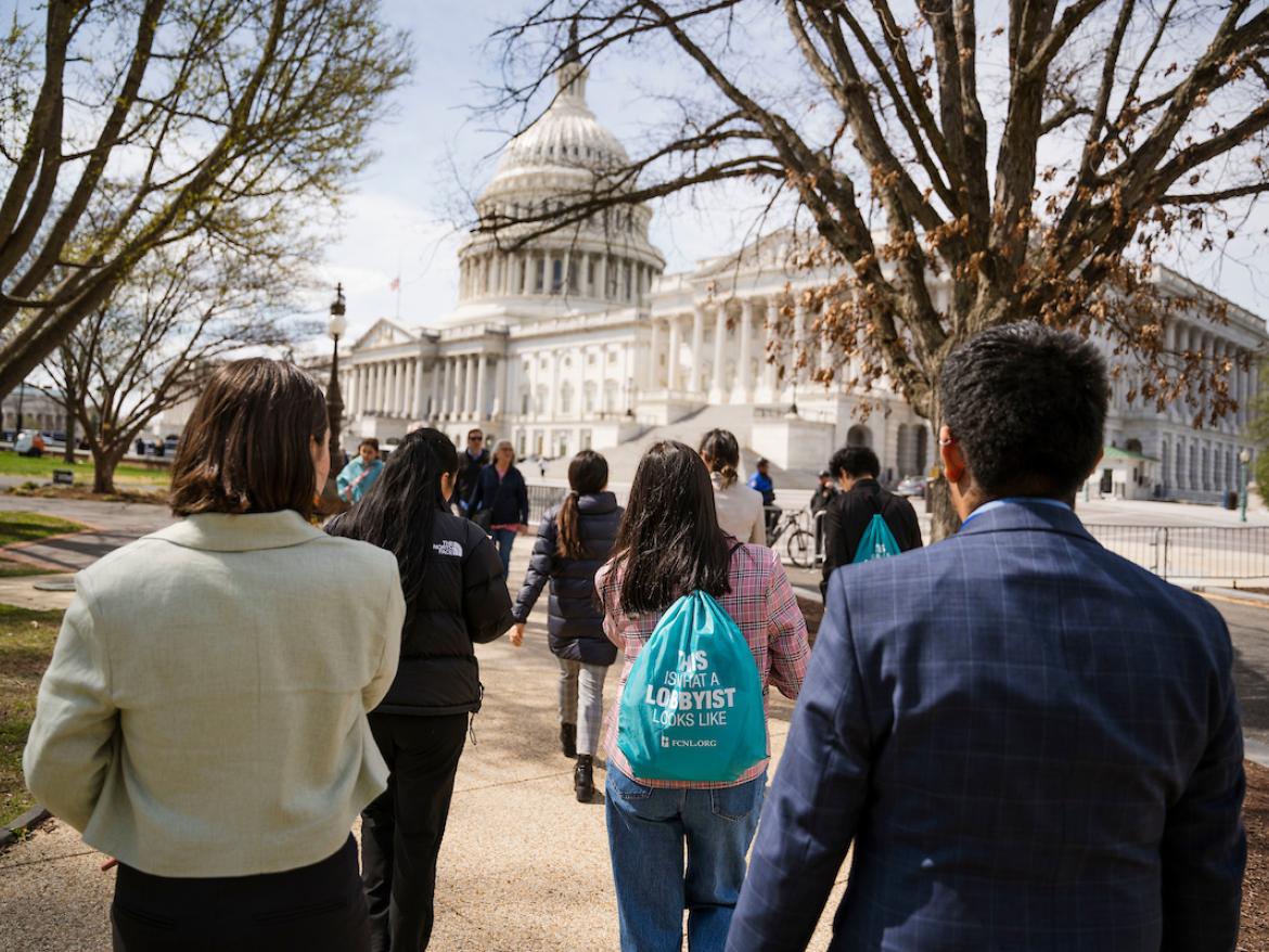 Group of young advocates walks toward the U.S. Capitol Building. One wears a backpack that says "This is what a lobbyist looks like"