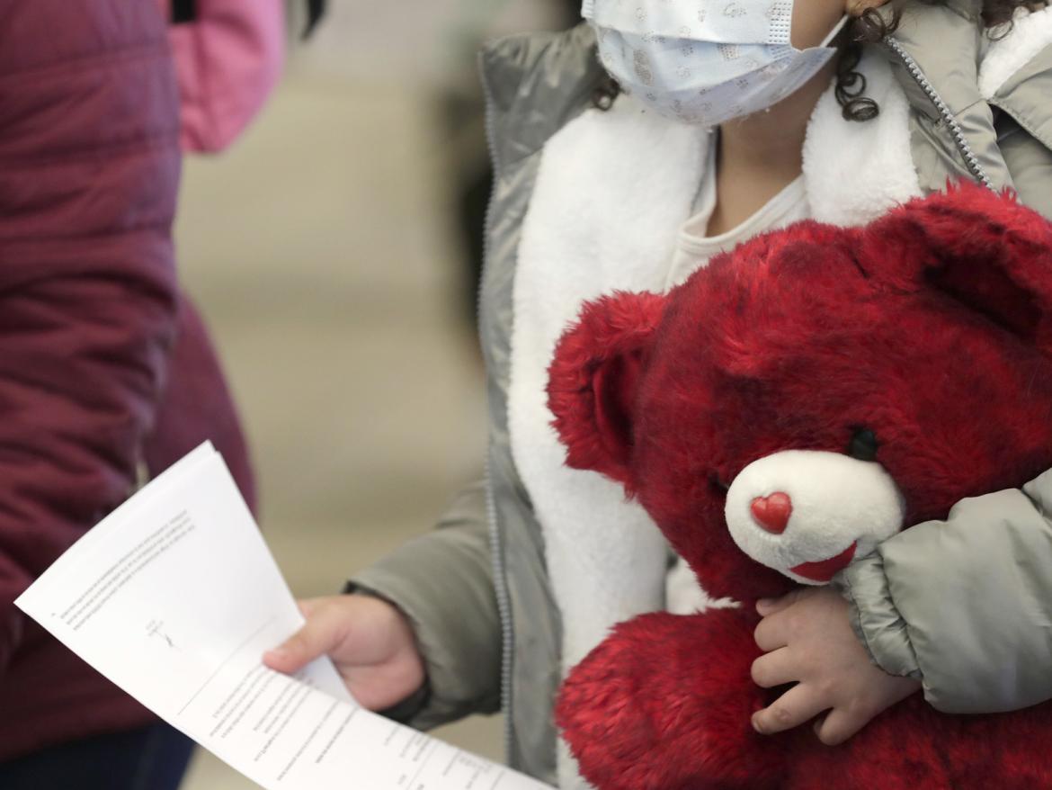 A child holds a teddy bear and document while U.S. Customs and Border Protection officers process their asylum claime at the Paso del Norte Port of Entry in El Paso, Texas