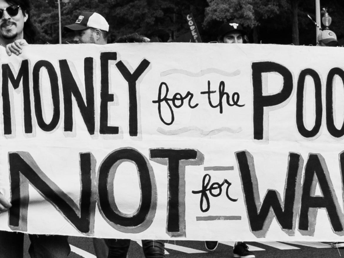 Marchers at the 2018 Poor People's Campaign rally hold a sign that says "Money for the Poor, Not for War"