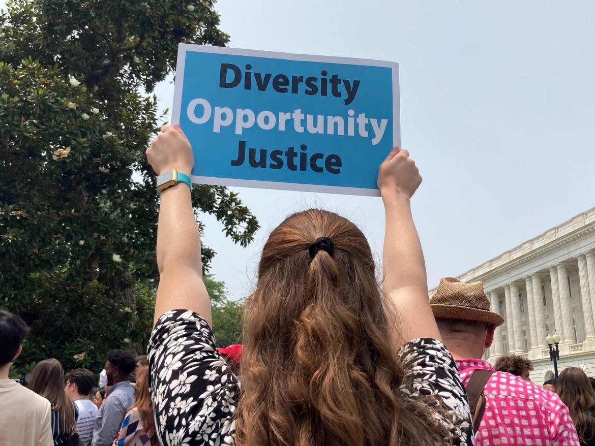 FCNL staff face U.S. Supreme Court, holding a sign that says "Diversity, Opportunity, Justice"