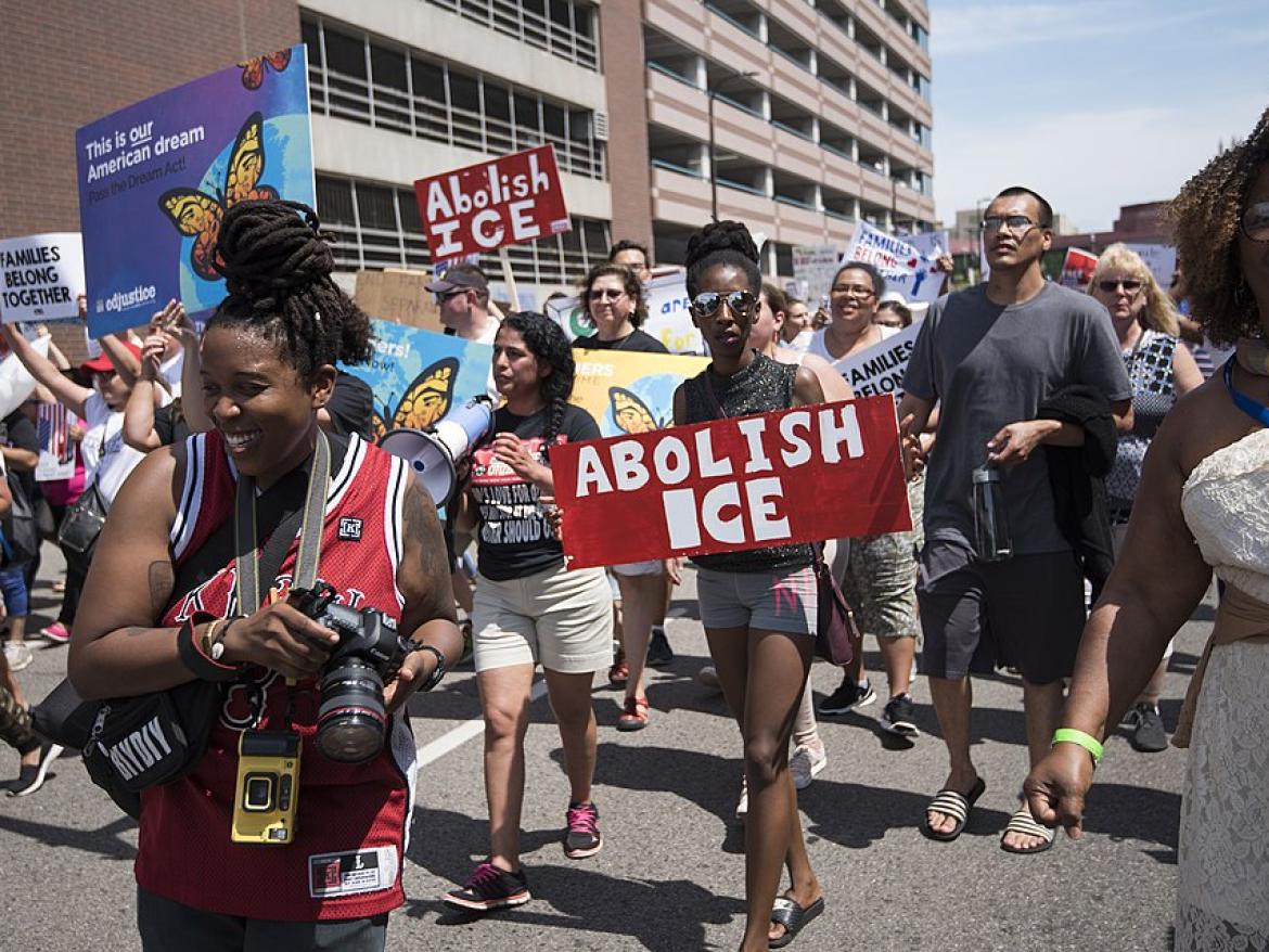A protest with people carrying signs that say "Abolish ICE"