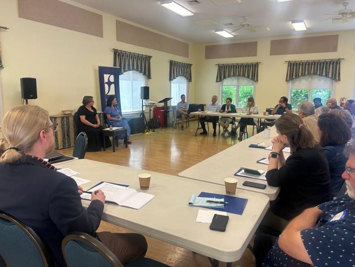 Faith leaders gathered around a table for a training