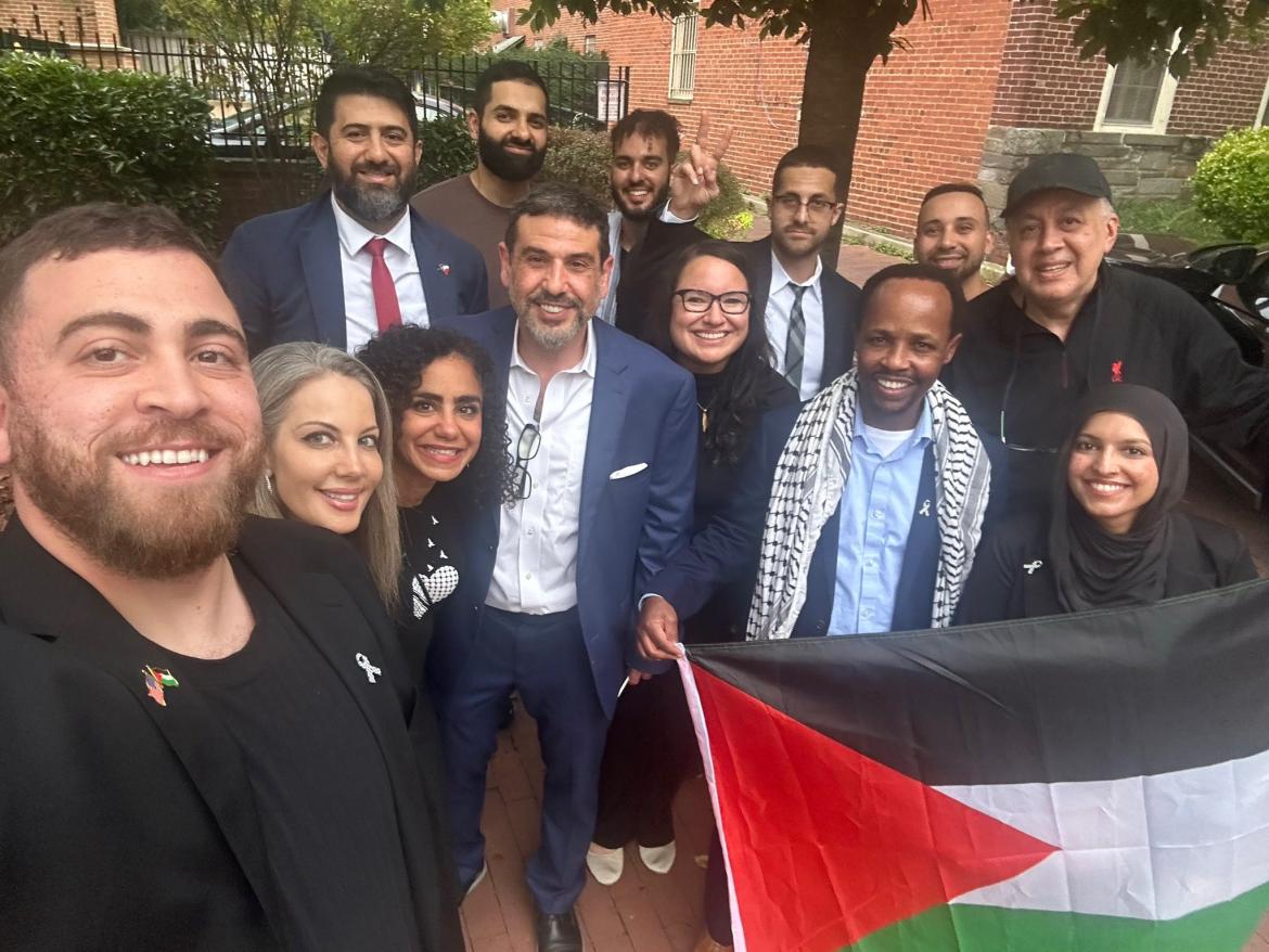 People posting in front of FCNL's office with a Palestinian flag