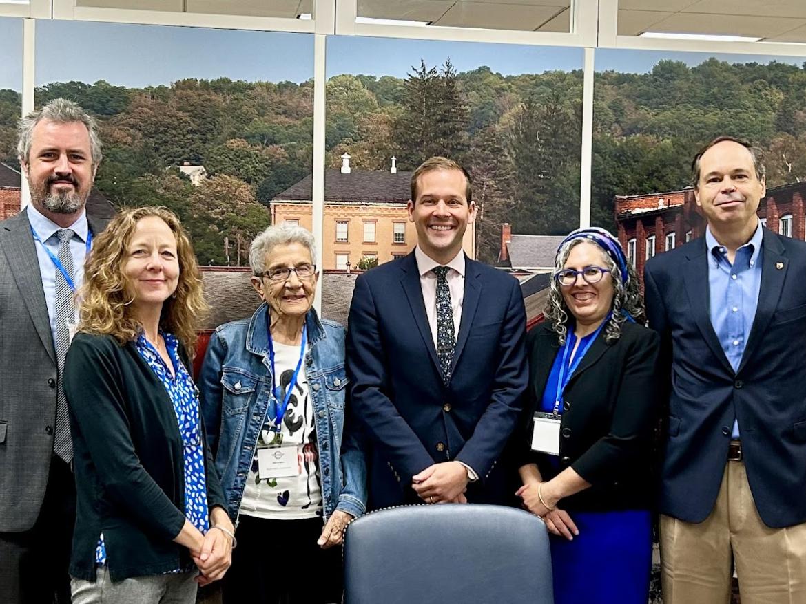 People smiling in front of panel photos