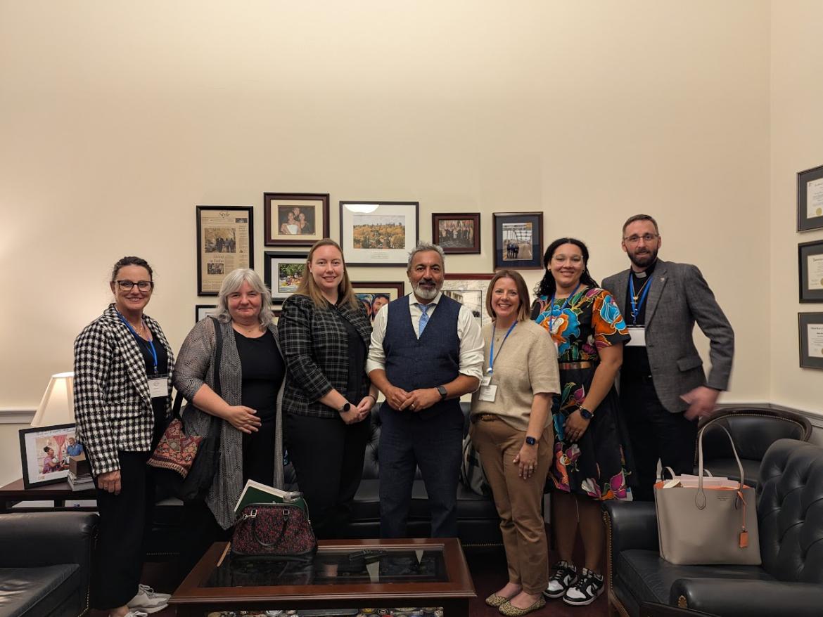 People smiling in an office in front of photos