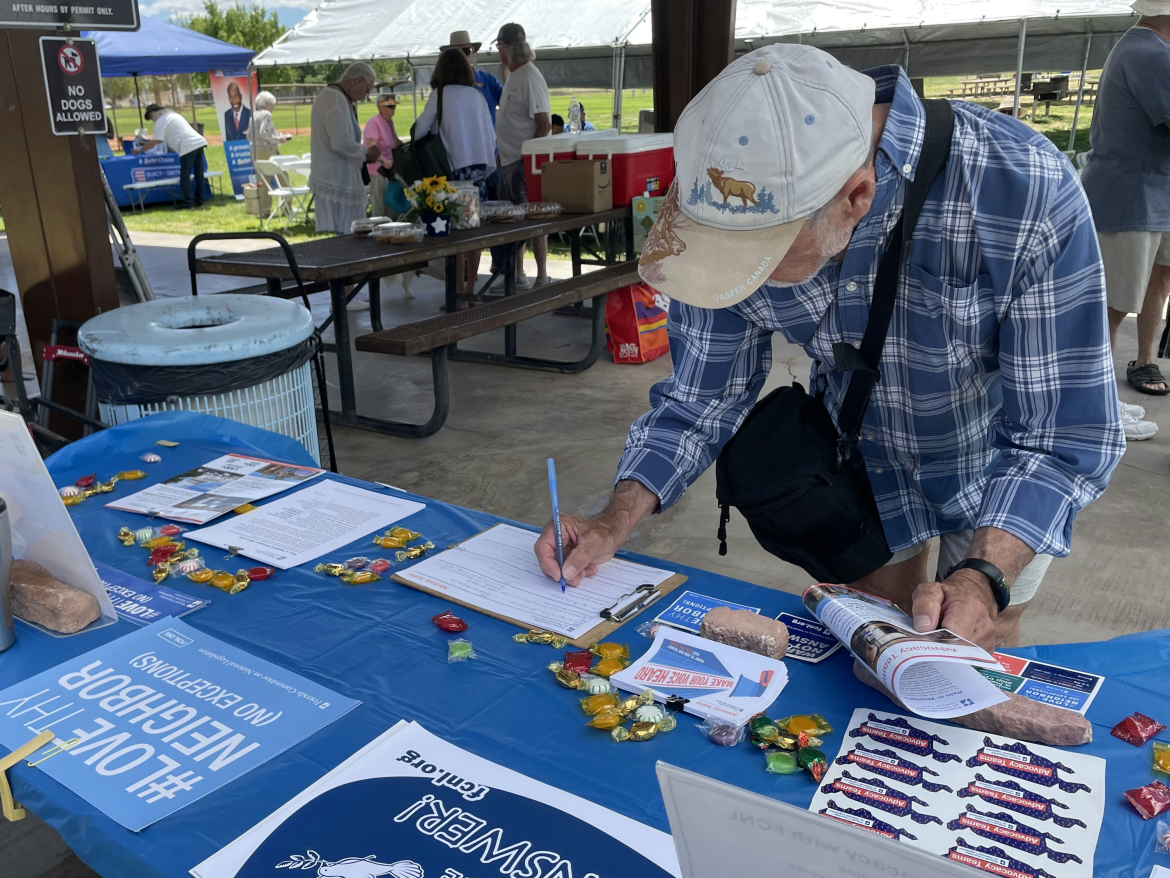A man signs up at an FCNL table