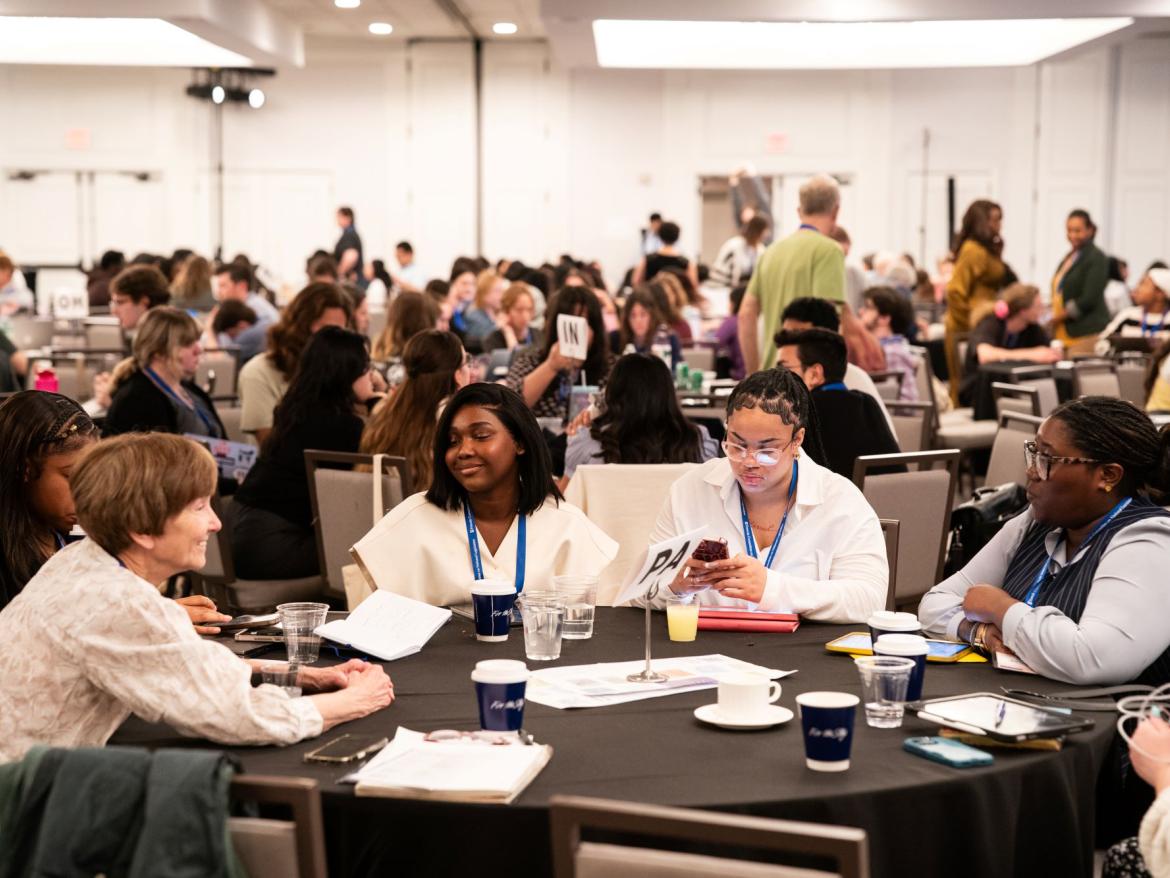 A crowd shot of people gathered at tables