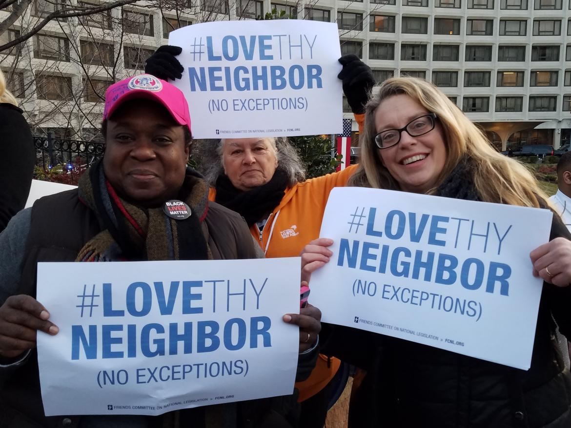 Diane Randall and a crowd holding signs that say Love Thy Neighbor, no exceptions