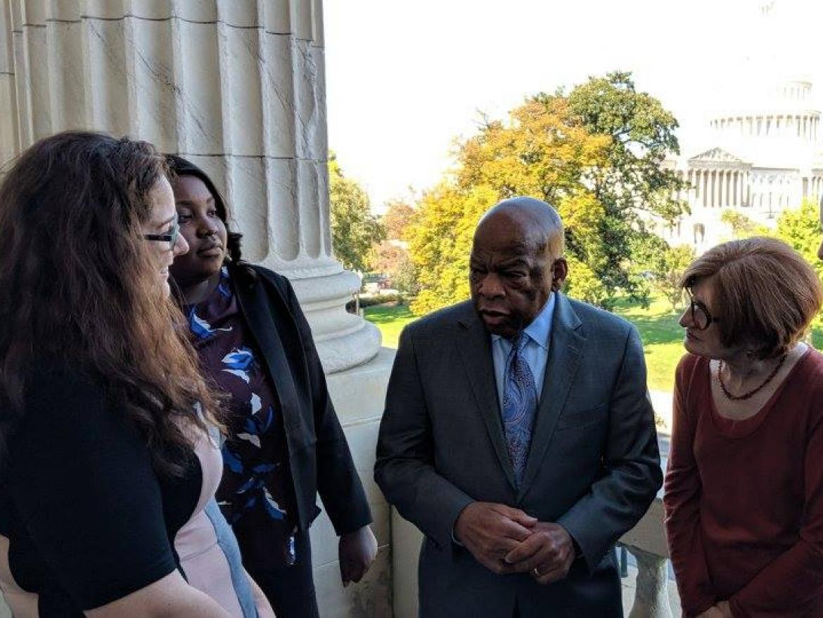 Five people meet with Rep. John Lewis in front of the Capitol