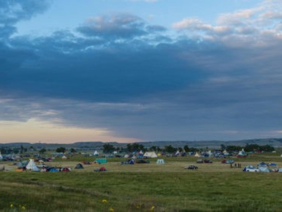Wide landscape at dusk with teepees and tents at Standing Rock