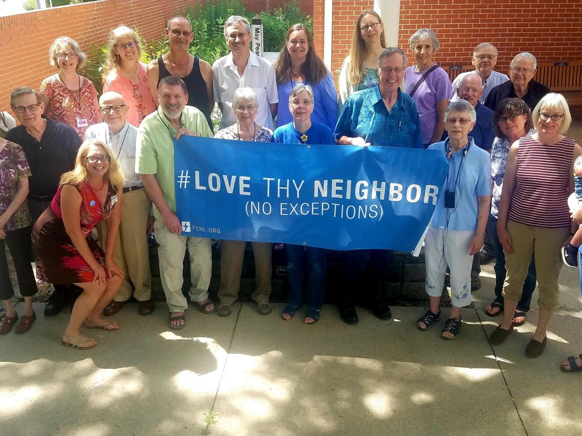 Christine Ashley with Friends holding Love They Neighbor banner
