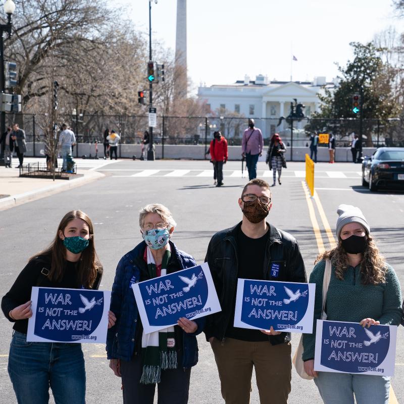 DC Advocacy team witness at White House holding "War is Not the Answer" and "AUMF Repeal signs