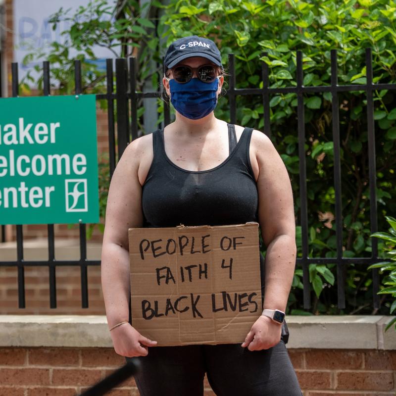 Adrienne holding sign that says "People of Faith for Black Lives" outside Quaker Welcome Center