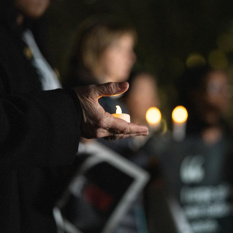 Faithful advocates hold candles at a vigil for peace
