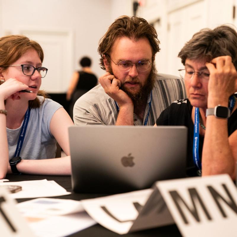 A group of people gathered around a computer