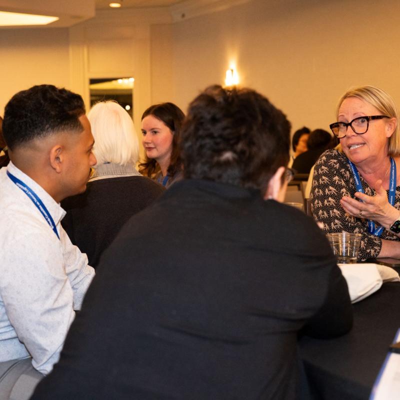 A conversation between people seated at a table