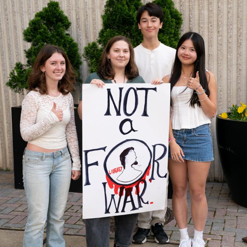 Teens with a sign that says "not another penny for war"