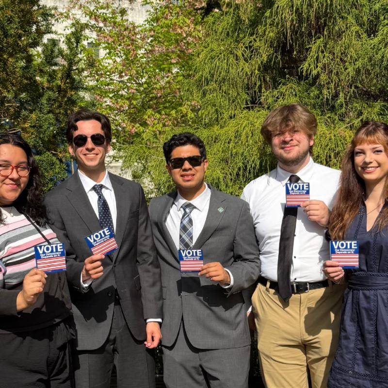 Young people professionally dressed with "Vote" stickers
