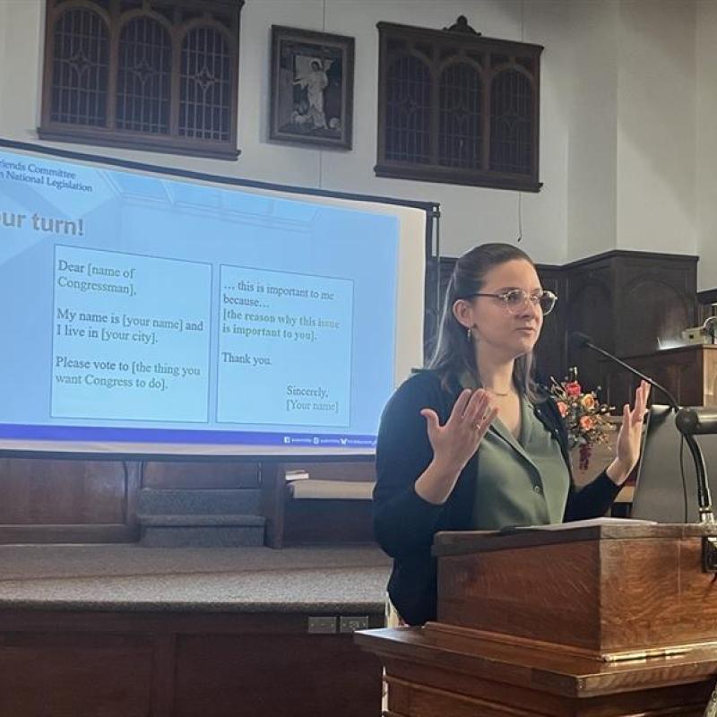 Susan Nahvi speaking in front of a screen