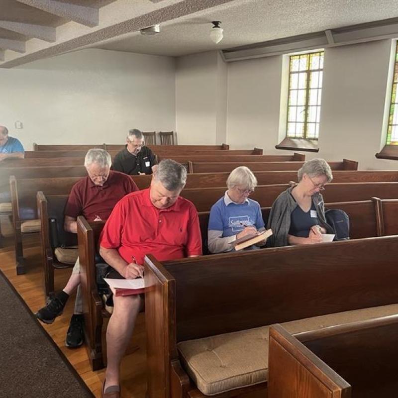 People taking notes in pews
