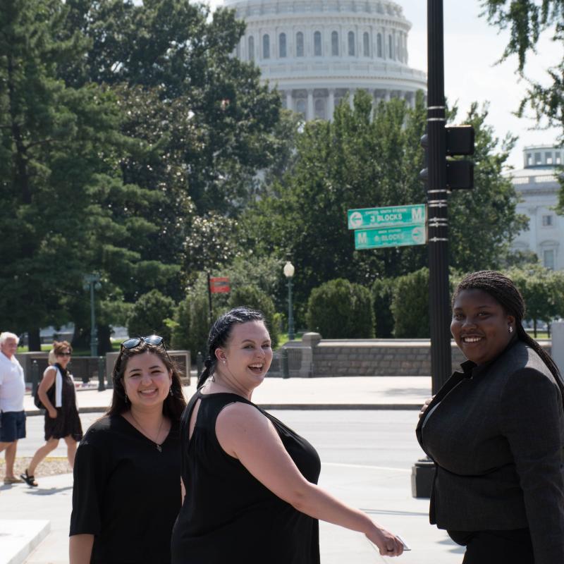 Young adults looking back at the camera while walking to the Capitol.