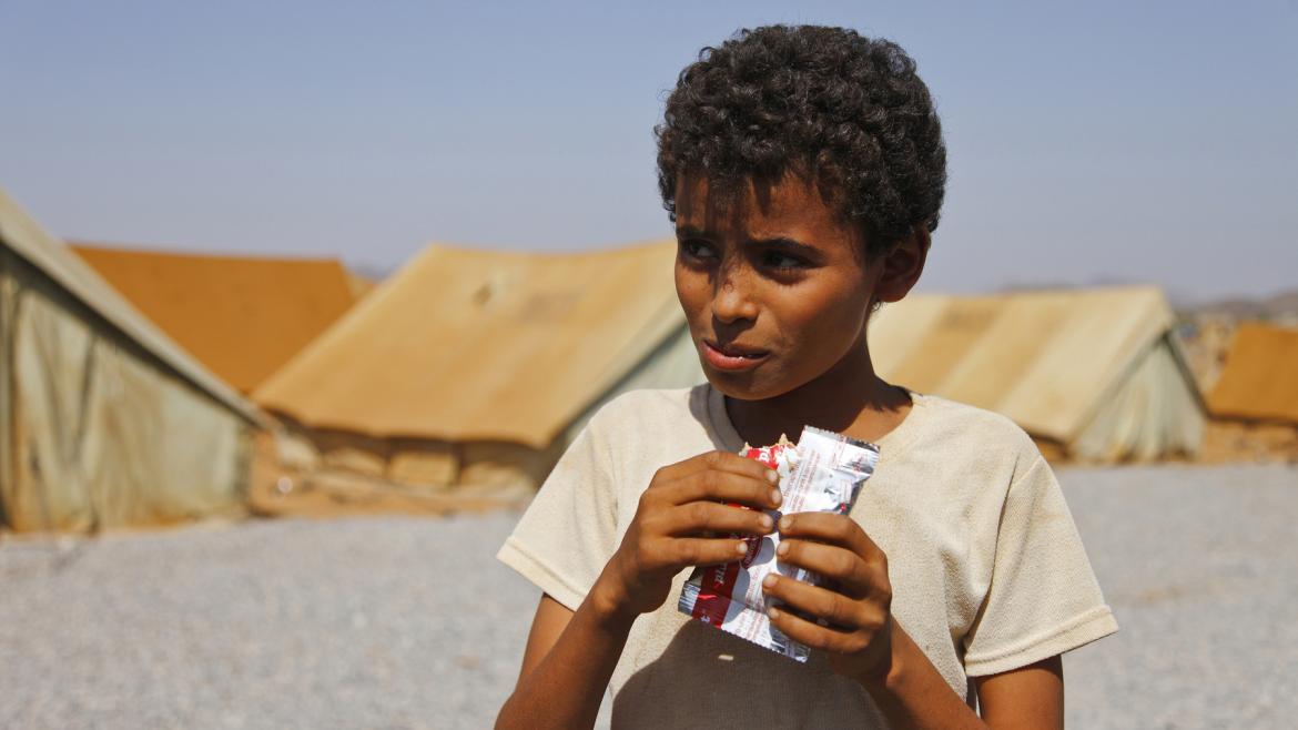 A Yemeni boy in Mazrak IDP camp in north-west Yemen, seen on 13 November, 2009, eats from a satchet of 'Plumpynut', a peanut-based food used in famine relief. UNICEF, the UN's children's fund, has been distributing the food among children in the camp to counter malnutrition. 