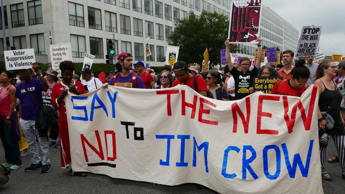 Protestors carry sign that reads: "Say no to the new Jim Crow"