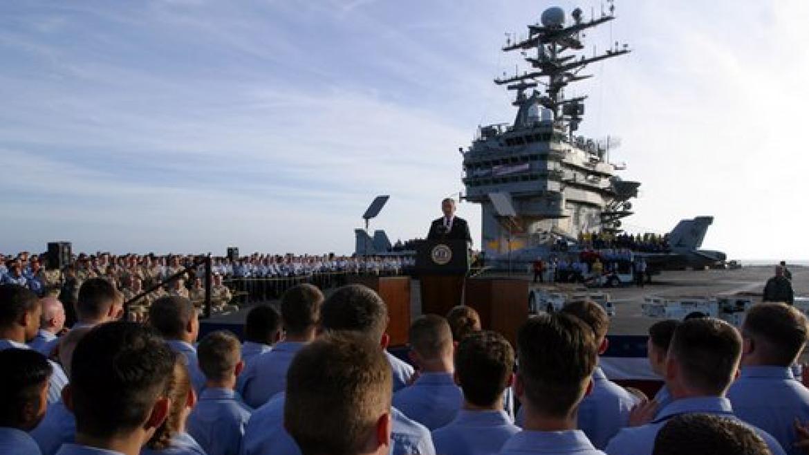 President George W. Bush addresses sailors and the nation from the flight deck of the USS Abraham Lincoln of the coast of San Diego, California May 1, 2003. A "Mission Accomplished" banner - which refers to operation Iraqi Freedom - hangs from the control tower in the background.