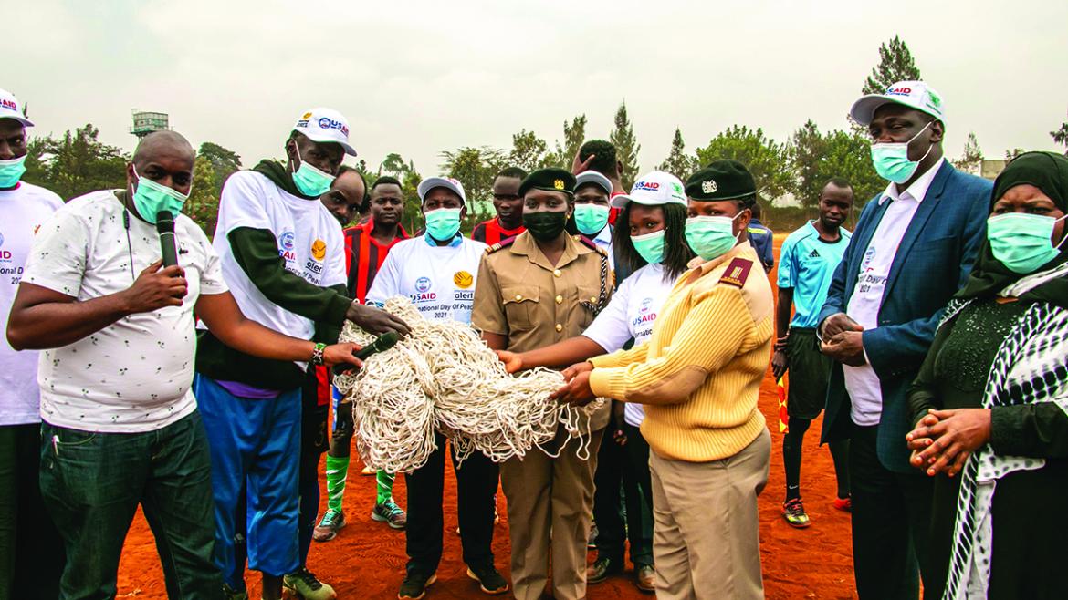 Participants of a peace walk in Kenya receiving footballs and goal nets in Kenya. 