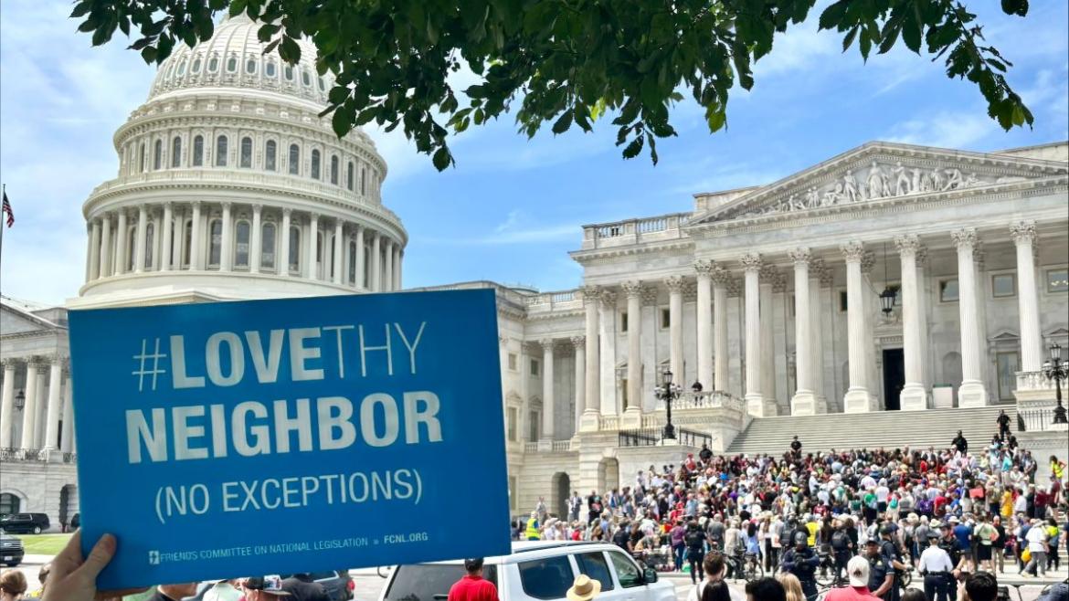 Love thy neighbor sign in front of Capitol and crowd